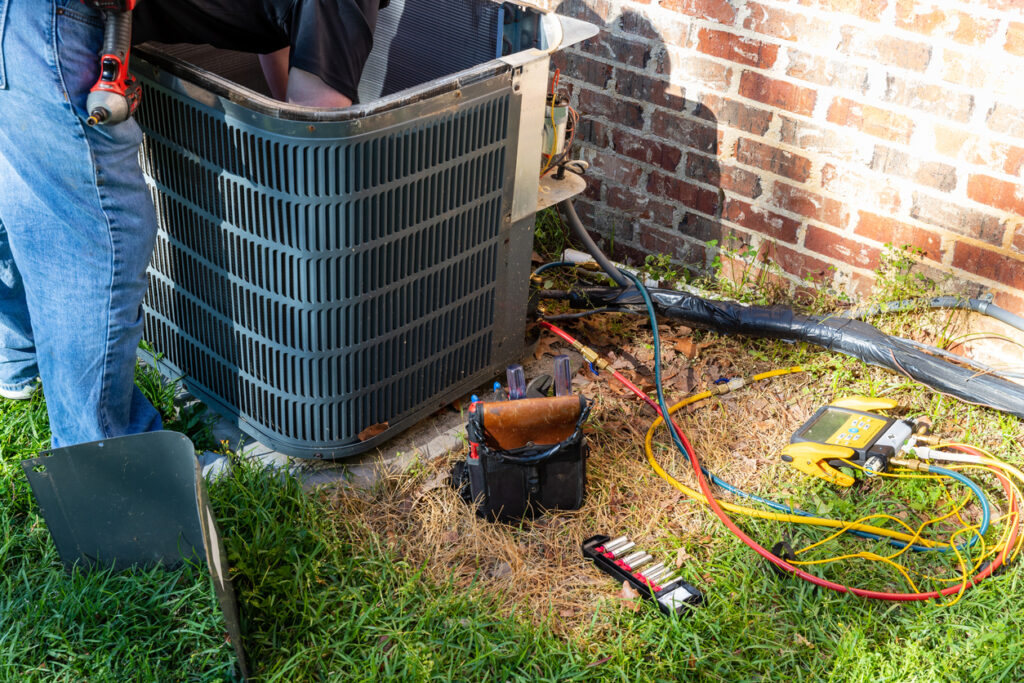 Service professional performing routine maintenance on an AC unit