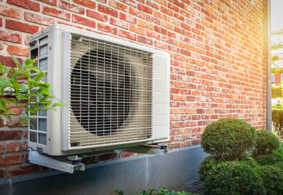 Heat pump wall mount on a brick wall of a house